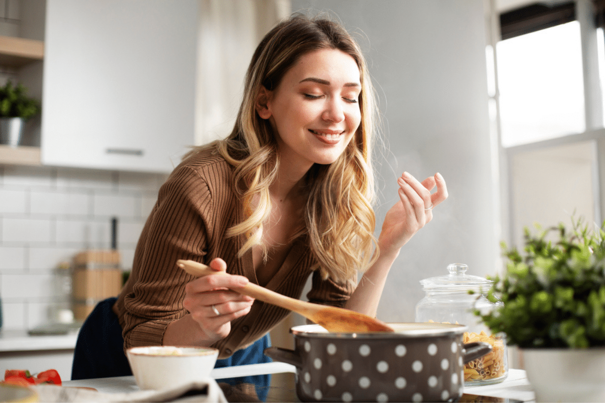 Una donna che ti mostra cosa sostituire il sale assaggiando il cibo