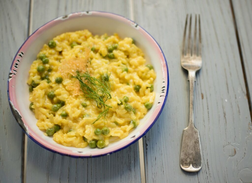 Risotto ai piselli servito con la forchetta d'argento