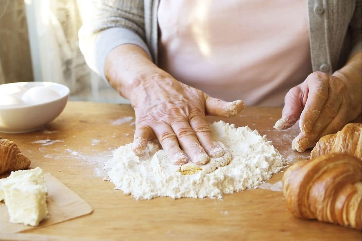 donna anziana che cucina un impasto